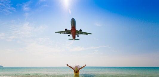 kobieta cieszy się gdy samolot leci nad plażą Mai Khao na phuket, tajlandia