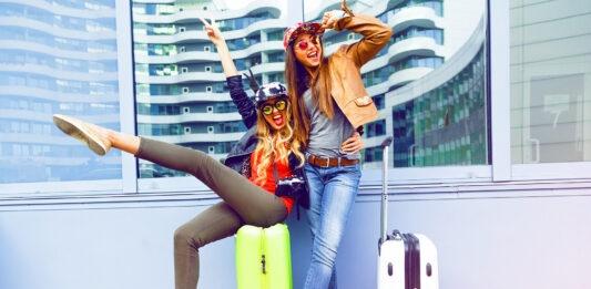 młode kobiety z walizkami cieszą się na lotnisku na wakacjach