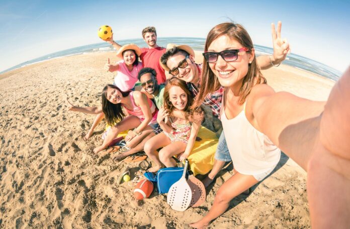 roześmiani młodzi ludzie na plaży