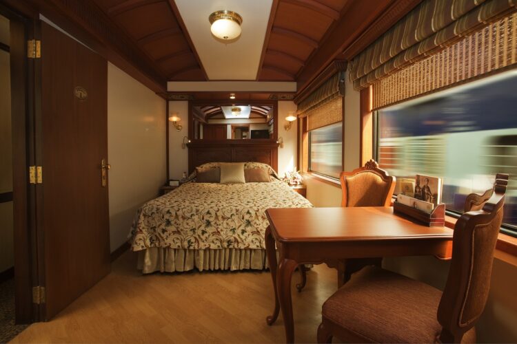 apartament w pociągu z łóżkiem stołem i krzesłami