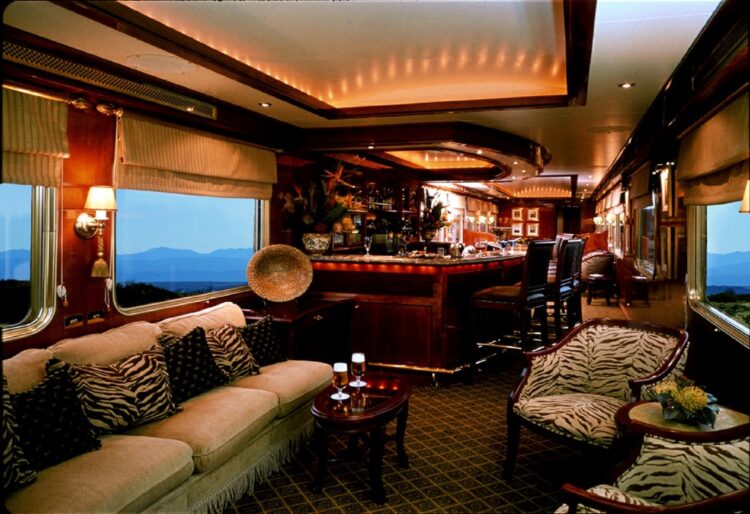 wnętrze salonu wypoczynkowego w pociągu z kanapami oraz barem