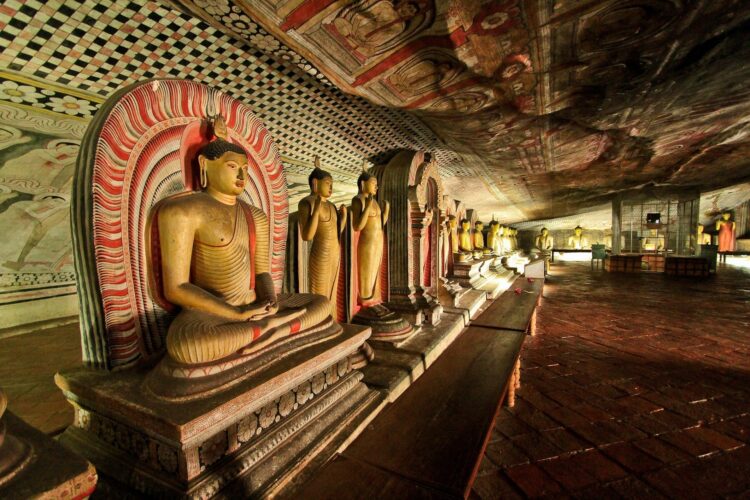 posągi buddy stojące pod ścianą