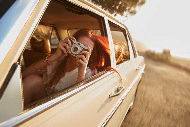 kobieta robi zdjęcie przez okno samochodu