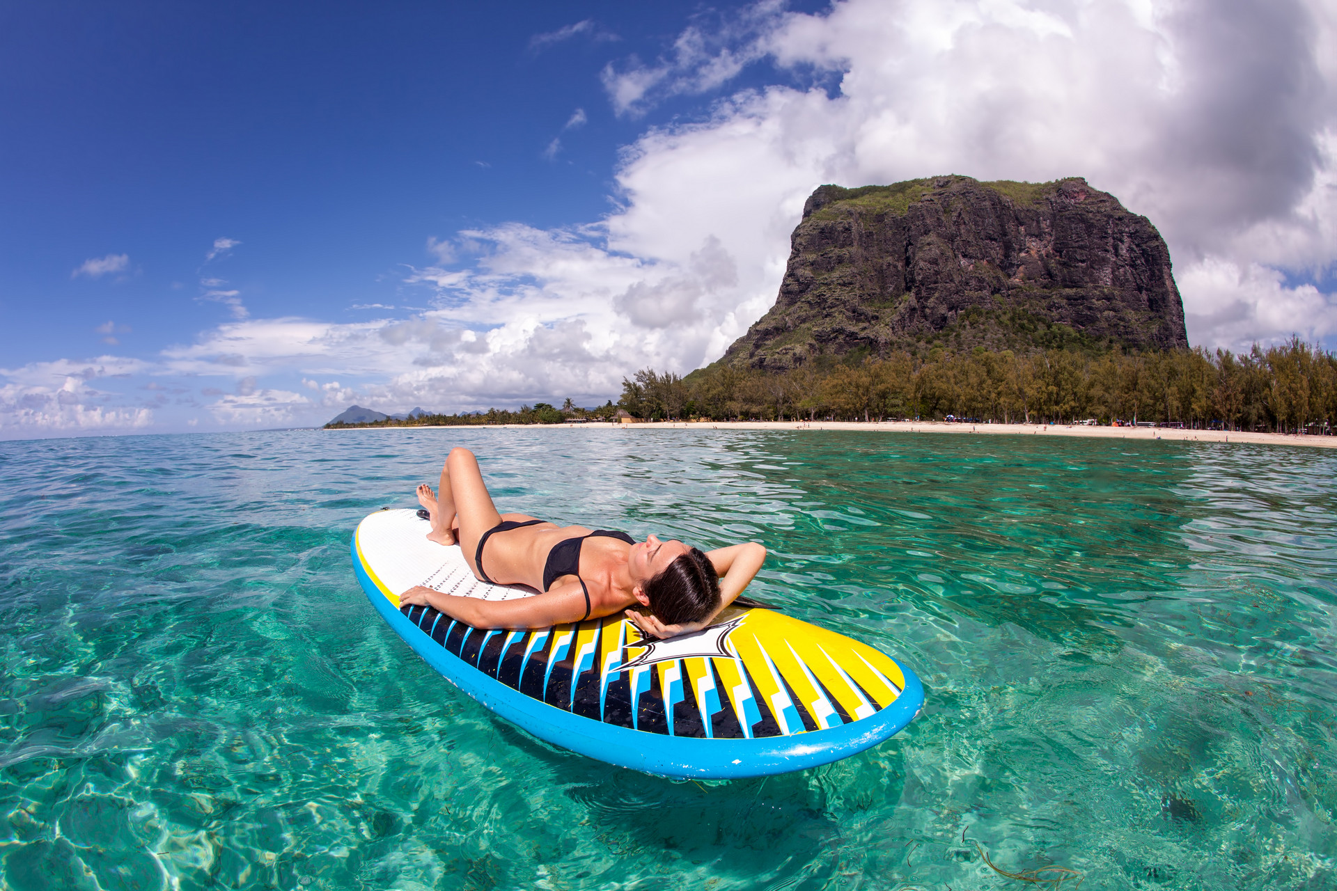 kobieta na materacu a w tle góra stołowa le morne brabant na mauritiusie