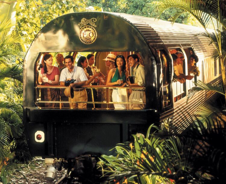 ludzie stojący na końcu pociągu i podziwiający widoki w egzotycznej scenerii niezwykłe podróże koleją