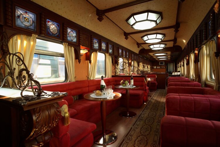 salon wypoczynkowy z czerownymi kanapami w pociągu golden eagle