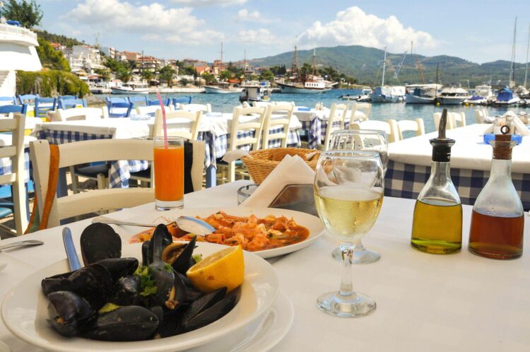 stół zastawiony greckimi potrawami owoce morza wino
