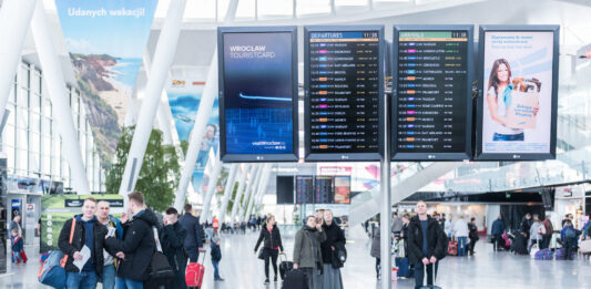 pasażerowie w hali przylotów i odlotów na lotnisku wrocław