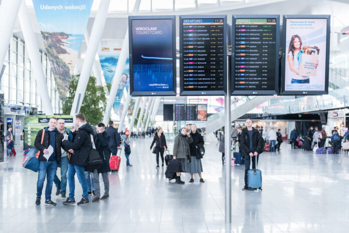 pasażerowie w hali przylotów i odlotów na lotnisku wrocław