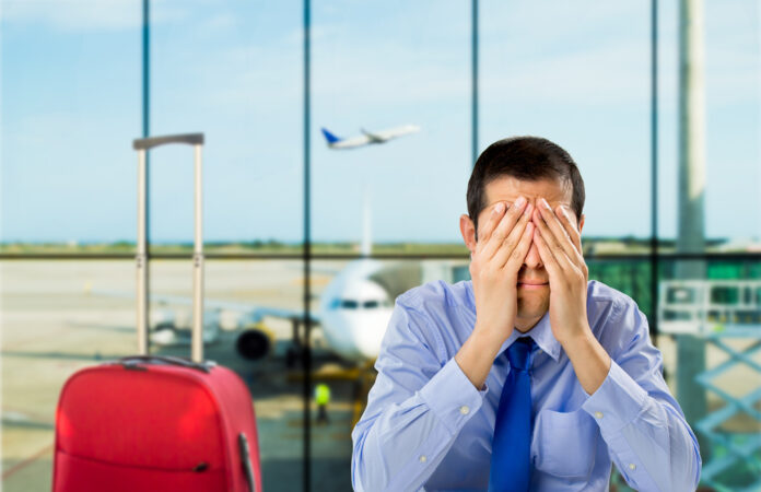 mężczyzna spóźnił się na samolot i siedzi smutny na lotnisku