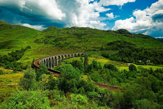 pociąg jadący przez wiadukt glenfinnan w szkocji