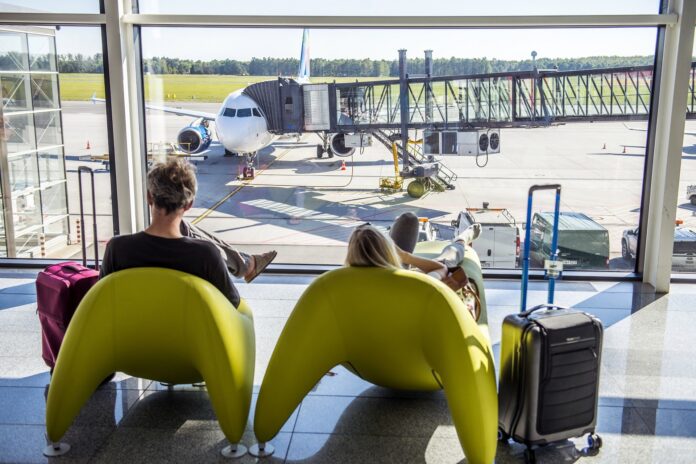 ludzie siedzący na fotelach na lotnisku