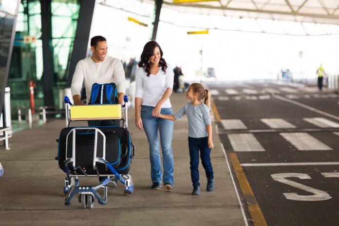 rodzina z bagażami przed lotniskiem