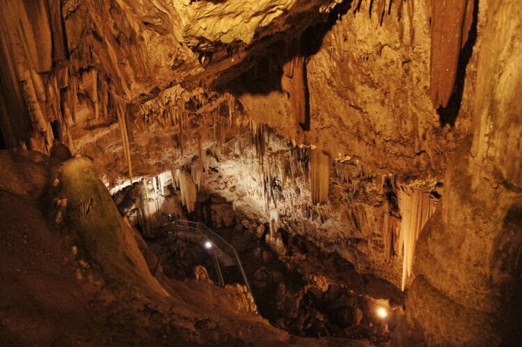 schody prowadzące do wnętrza jaskini ze stalaktytami i stalagmitami