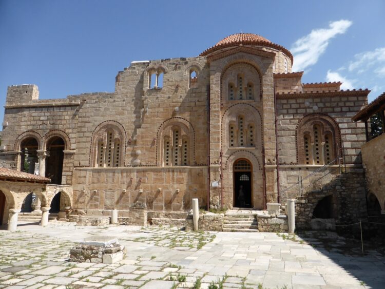 fasada bizantyjskiego kościoła zbudowanego z kamienia z pomarańczową kopułą