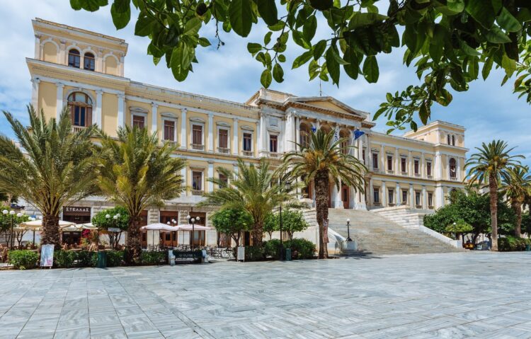 neoklasycystyczny budynek na marmurowym placu otoczony palmami