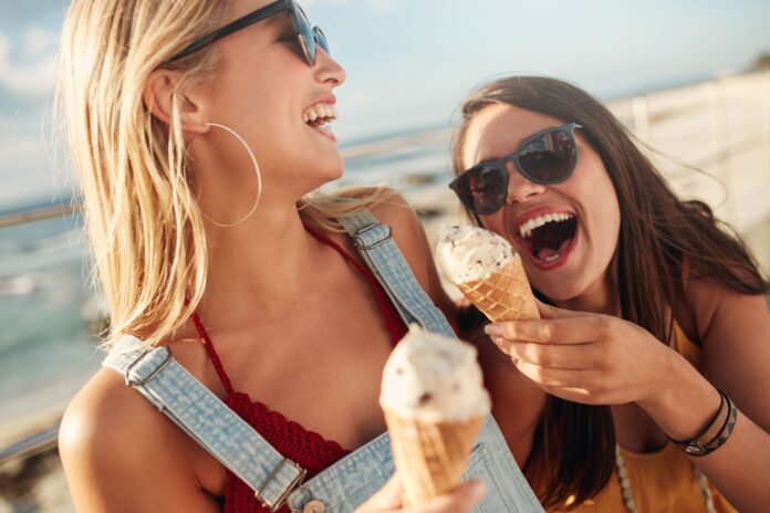 Dwie dziewczyny jedzące lody i śmiejące się