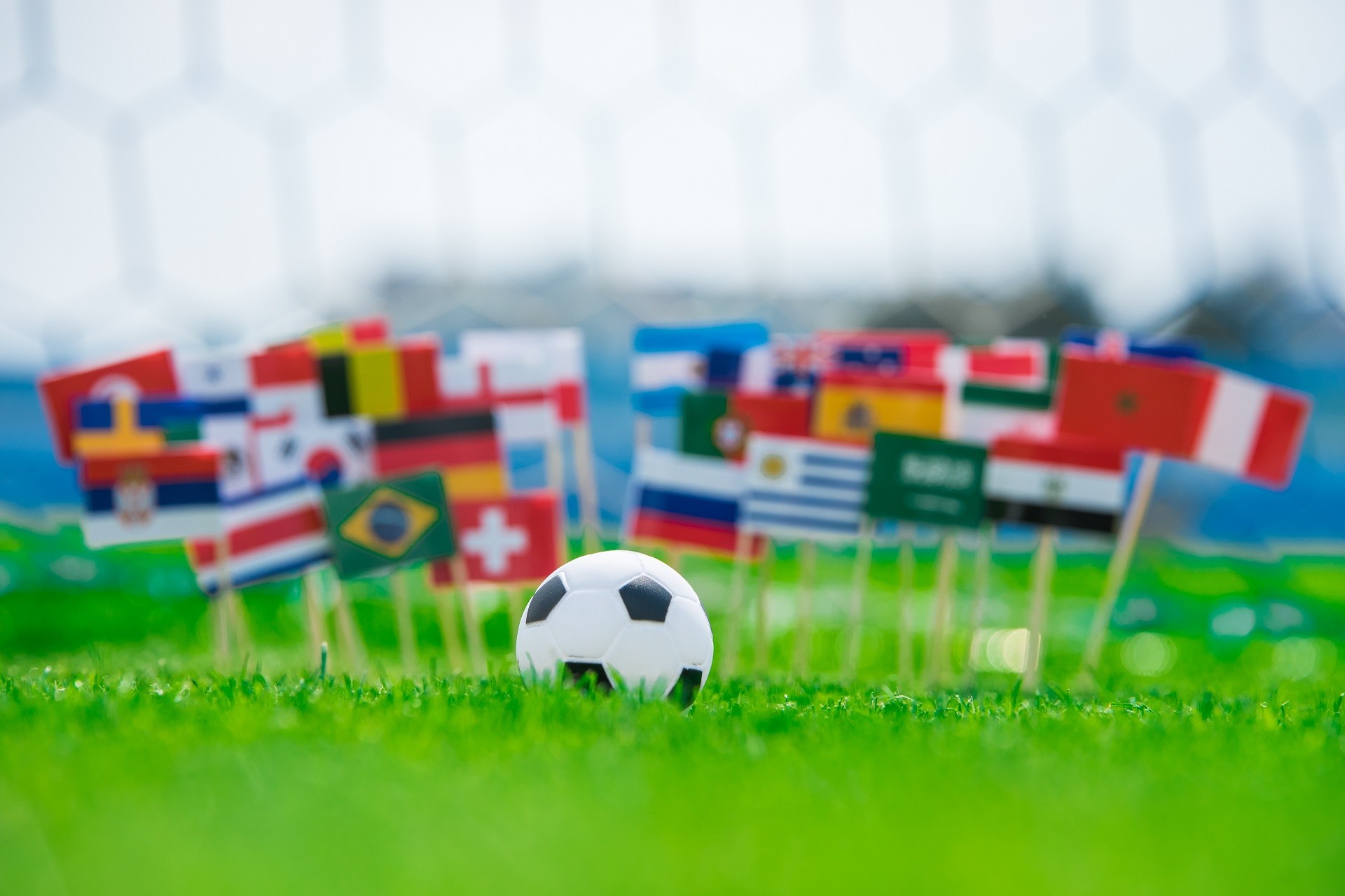 Piłka na boisku i flagi państw FIFA 2018