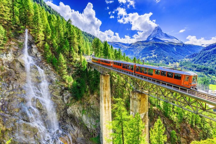 Szwajcaria i pociąg przy moście wodospadów i region Zermatt Switzerland. Gornergrat tourist train with waterfalll bridge and Matterhor Valais region