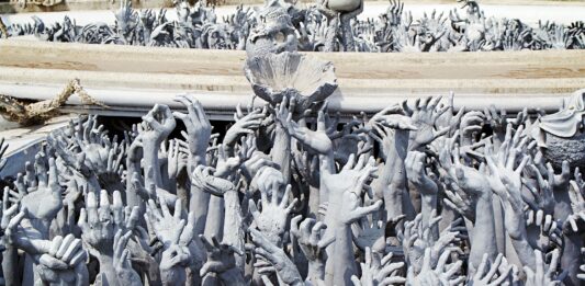 rzeźby białych rąk wyciągających się ku niebu