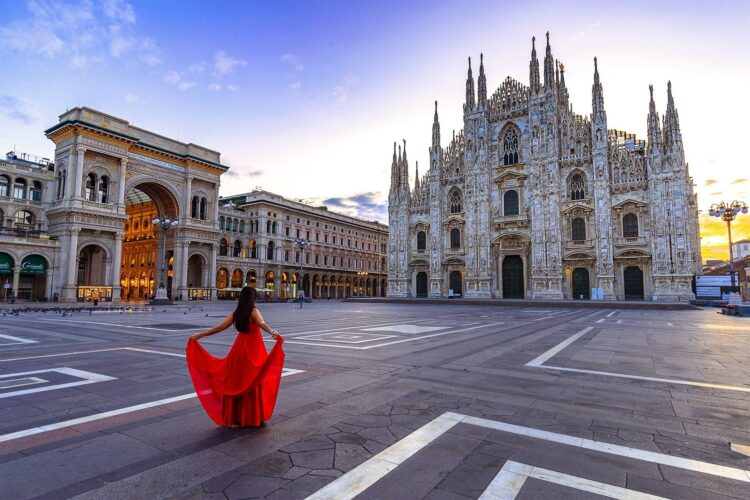 Kobieta w czerwonej sukni przed katedrą w Mediolanie