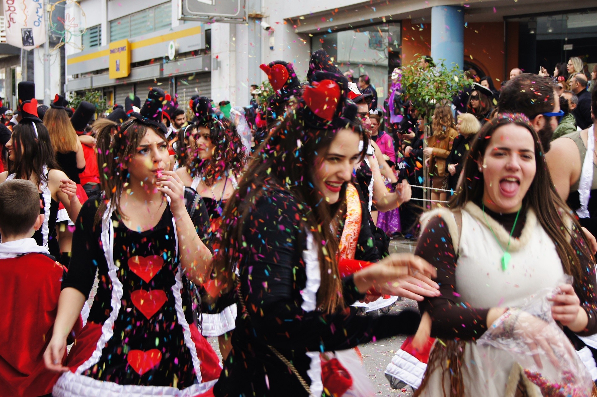 młode dziewczyny w karnawałowych strojach rzucające confetti