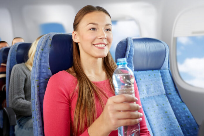 kobieta pije wodę w samolocie