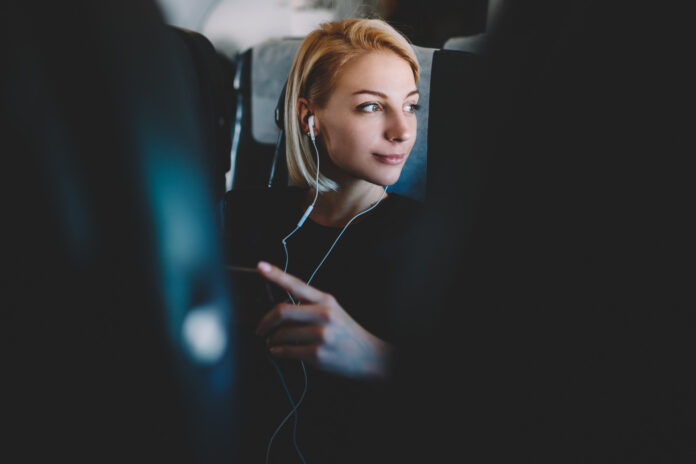 kobieta słucha muzyki na pokładzie samolotu