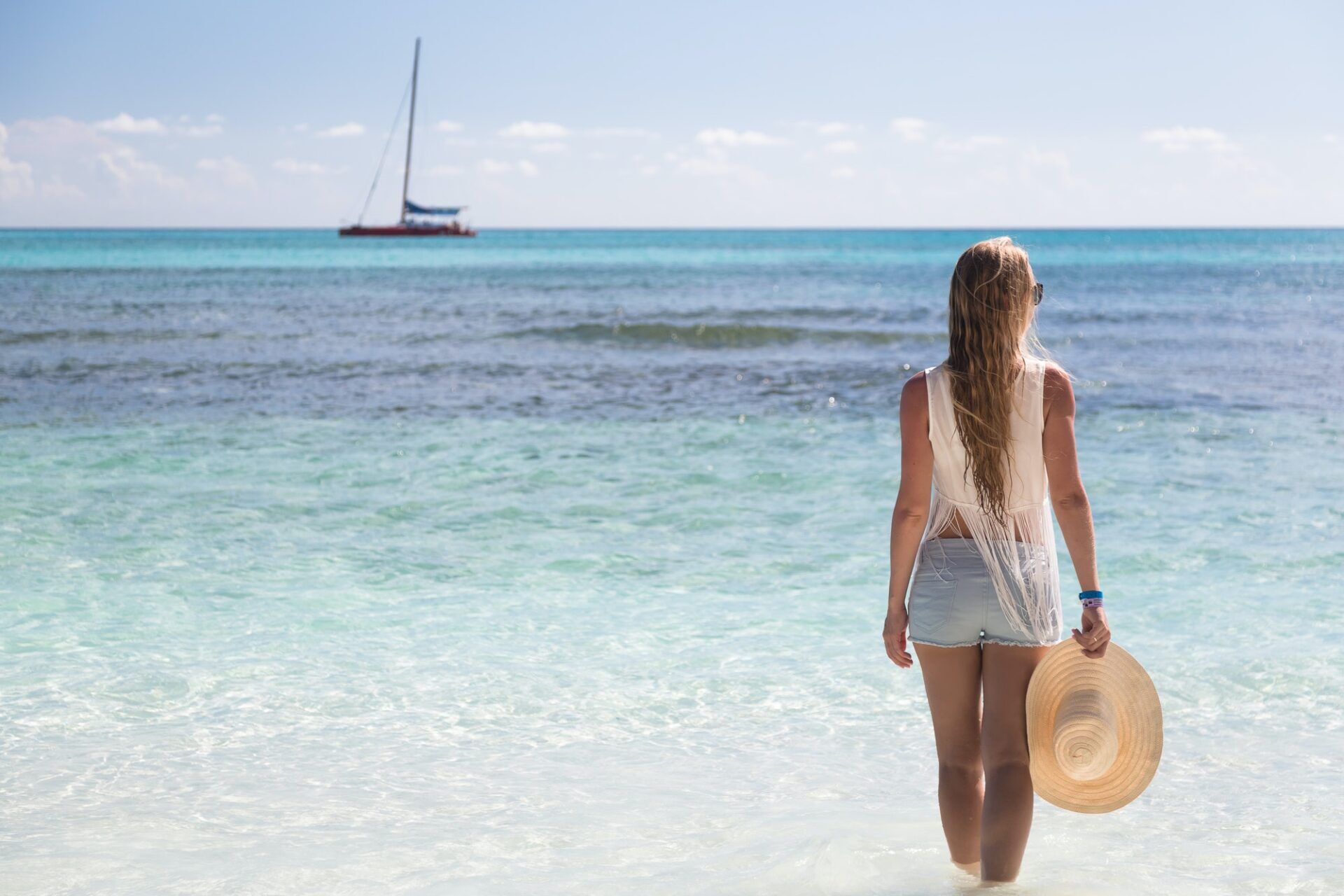 Girl stand in water looking to the sea, Saona