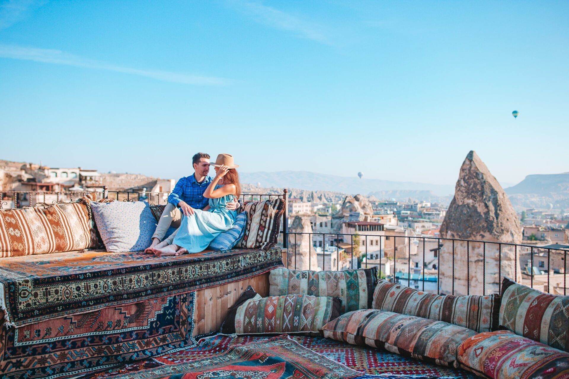 Happy young couple during sunrise watching hot air balloons in Cappadocia, Turkey