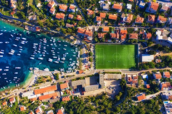Croatian seascape from air. Yacht and football stadium. Hvar island