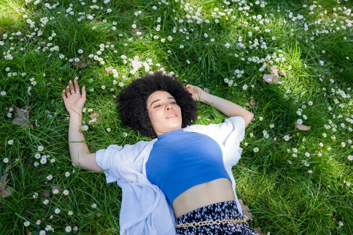 woman in the park lying on the grass, resting, relaxed, in spring