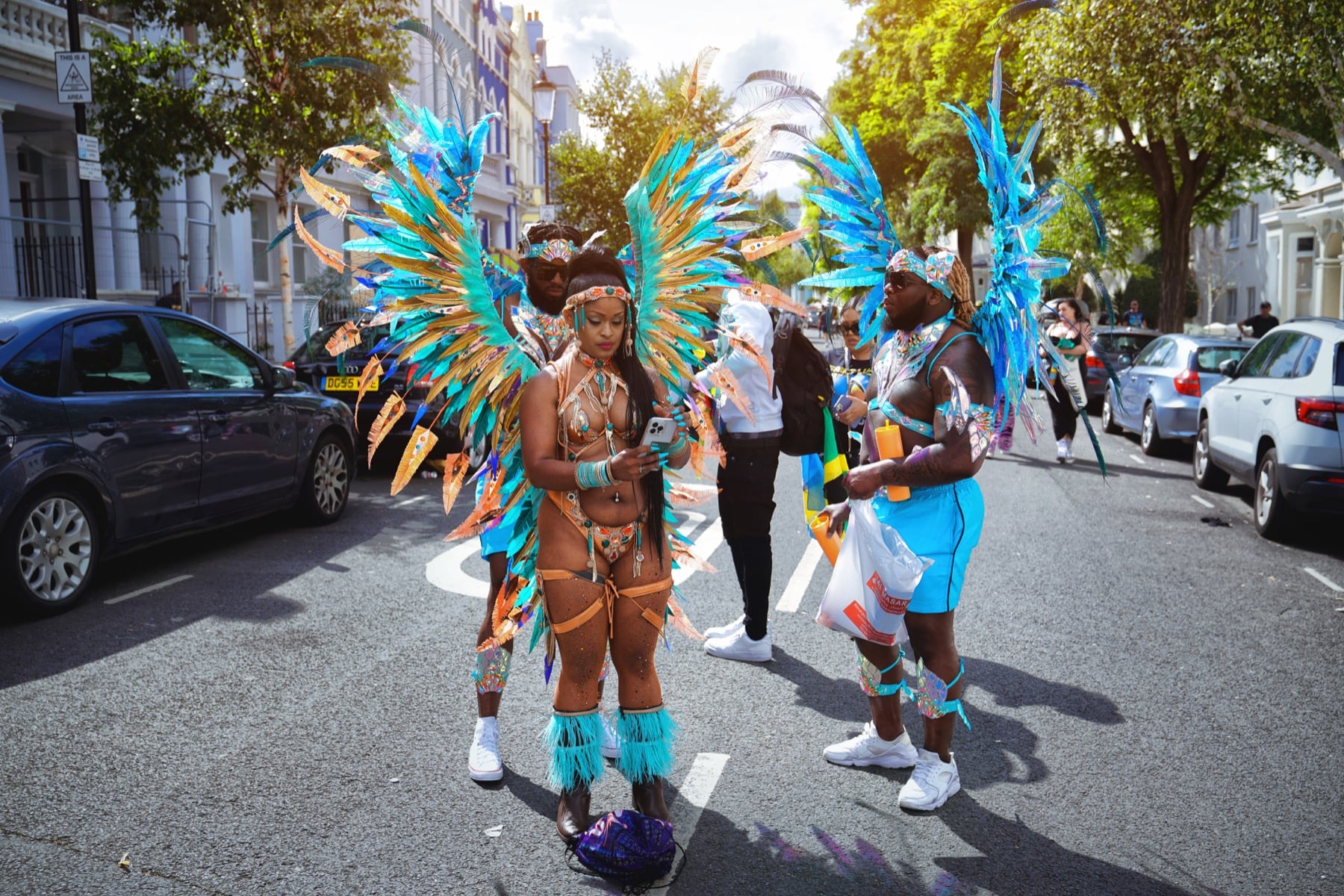 Uczestnicy Notting Hill Carnival w kolorowych kostiumach na ulicy w Londynie