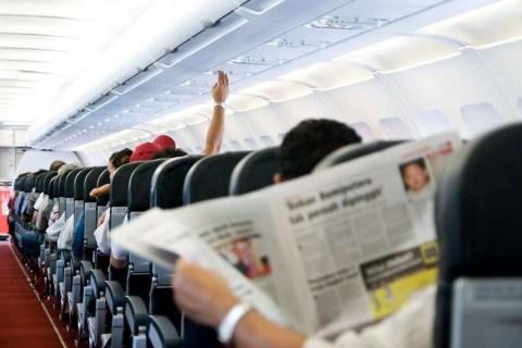 Reading-newspaper-in-a-plane-shutterstock_18487321-3