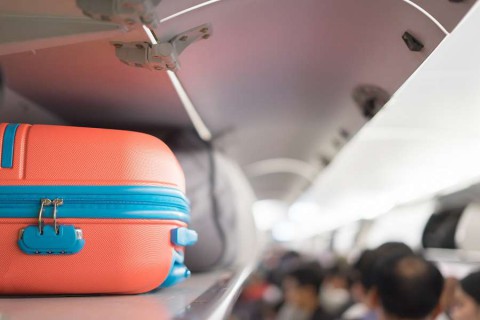 Carry-on-luggage-on-the-top-shelf-over-head-on-airplane-passenger-put-bag-cabin-compartment-air-craft-business-classvintage-colorcopy-space-shutterstock_599140022