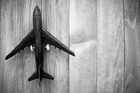 plane-on-wooden-background-top-view.-shutterstock_573373540