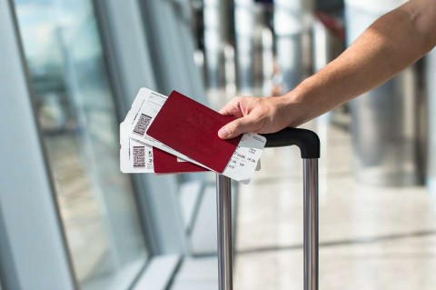 Closeup-of-man-holding-passports-and-boarding-pass-at-airport-shutterstock_210539380