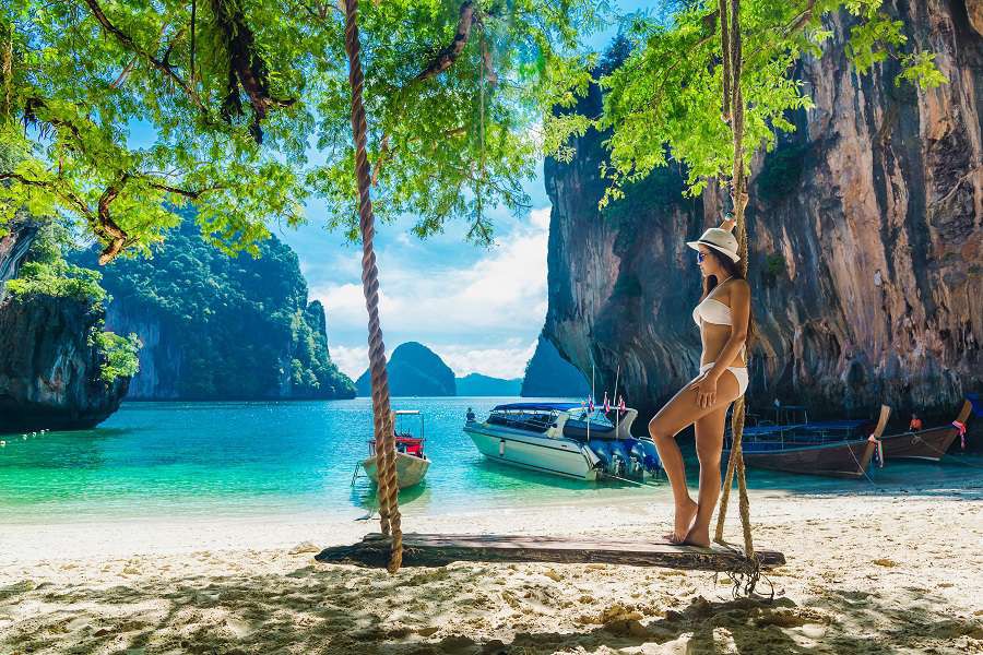 Beautiful-woman-in-bikini-relaxing-on-wooden-swing-under-tree-and-looking-destinations-sea-beach-Koh-Lading-island-Andaman-sea-Krabi-province-Thailand-shutterstock_651297709