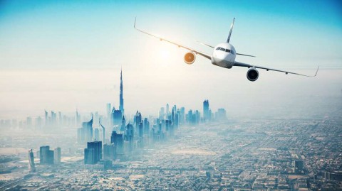 Commercial-airplane-flying-over-modern-city-shutterstock_400492300