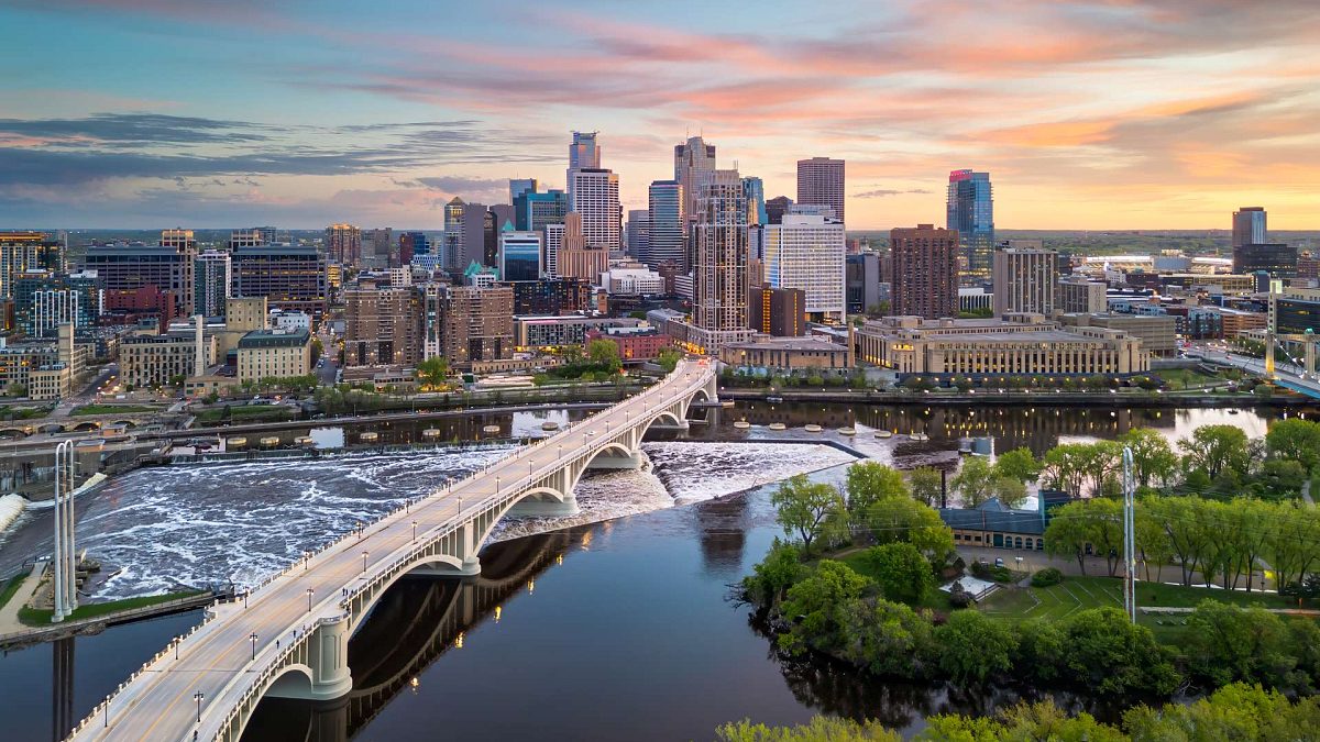 Panorama centrum Minneapolis nad Missisipi z mostem Third Avenue Bridge i wodospadem Saint Anthony Falls o zmierzchu